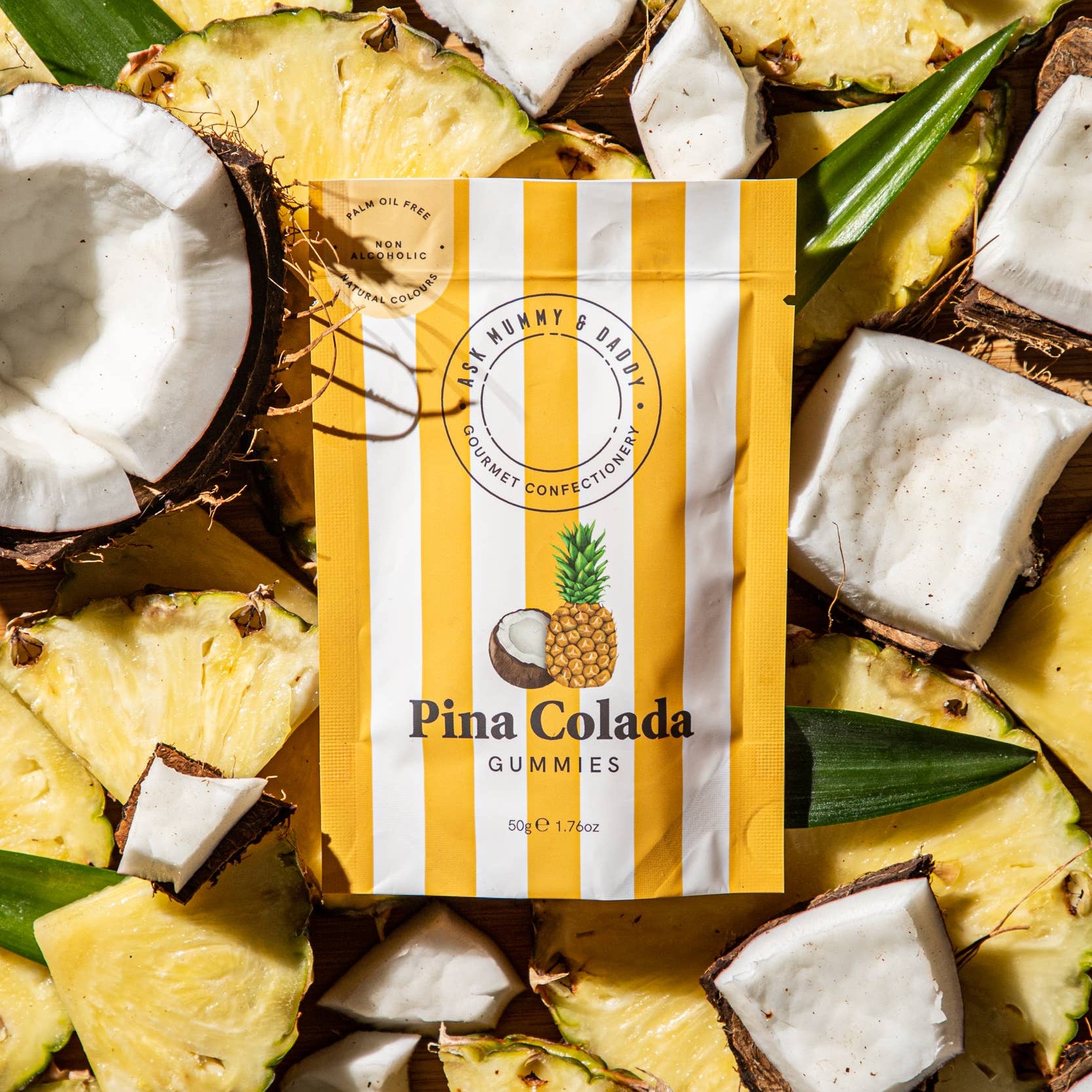 Pina Colada gummies pouch surrounded by fresh pineapple and coconut chunks