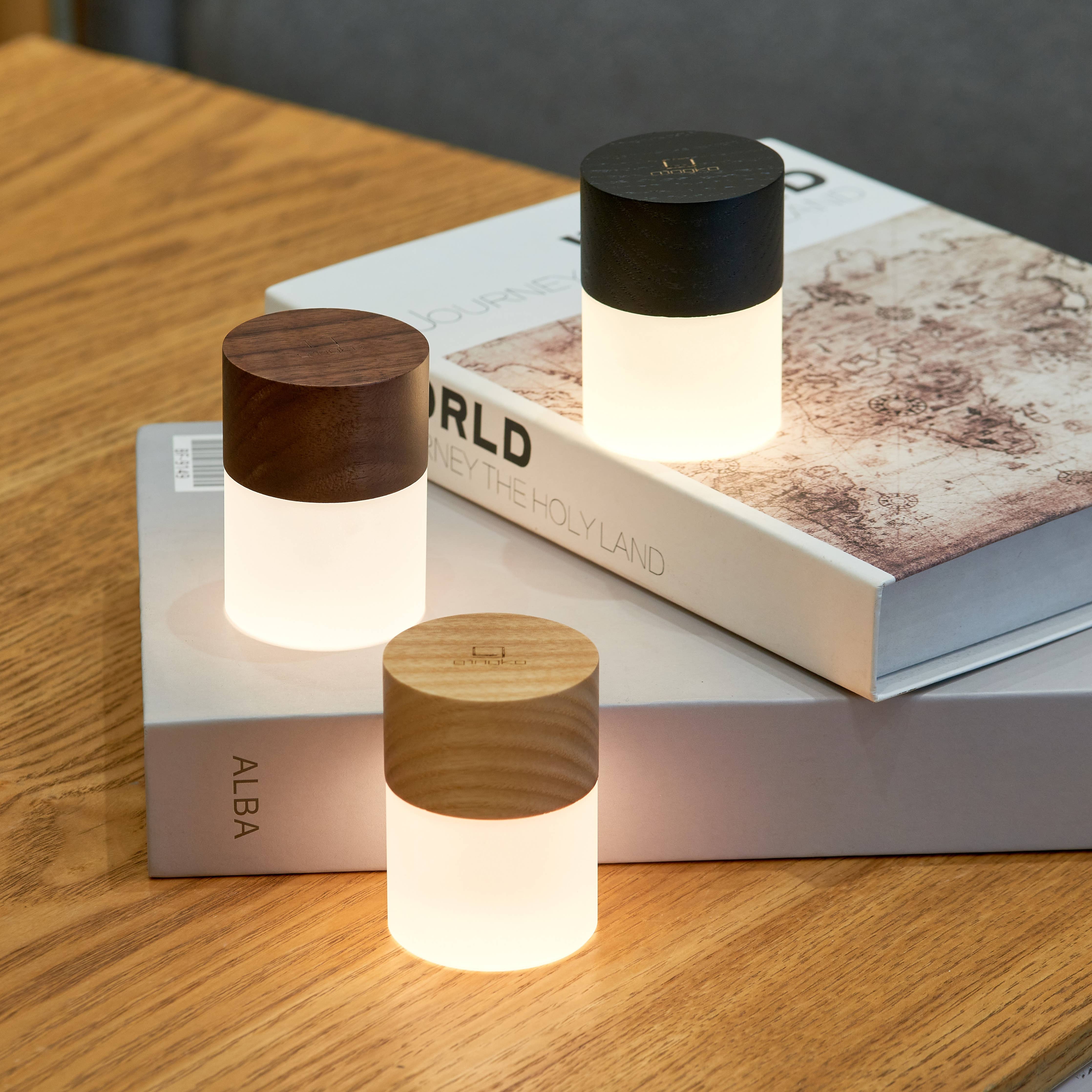 Three Lemelia lights arranged on stacked books, all glowing warm white