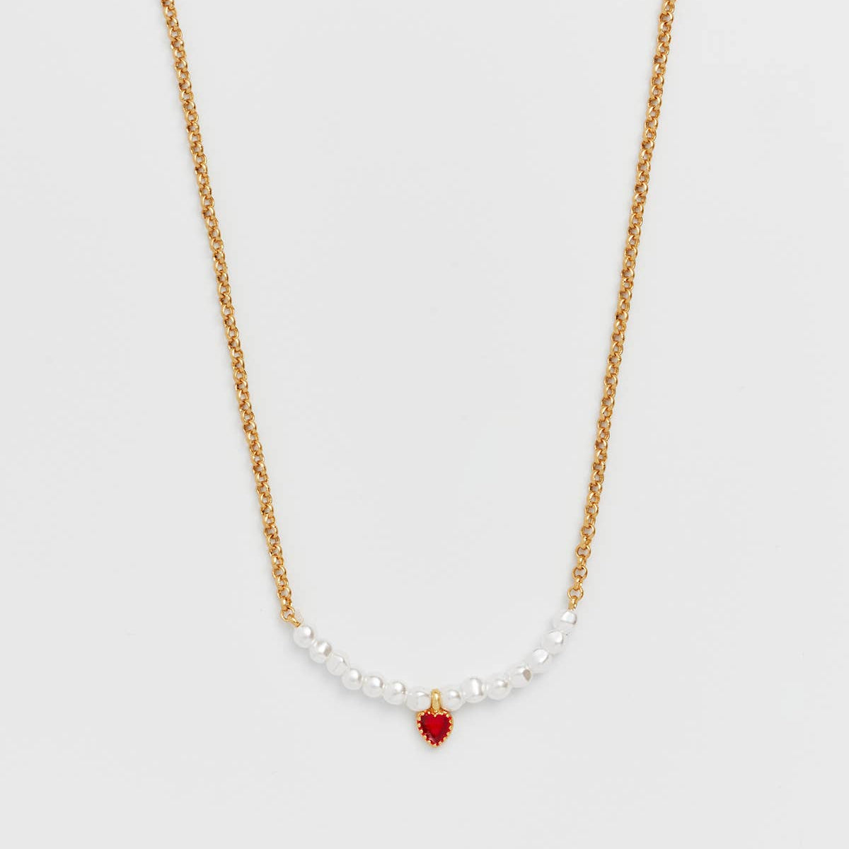 Gold chain necklace with a centre pearl section and small red enamel heart charm