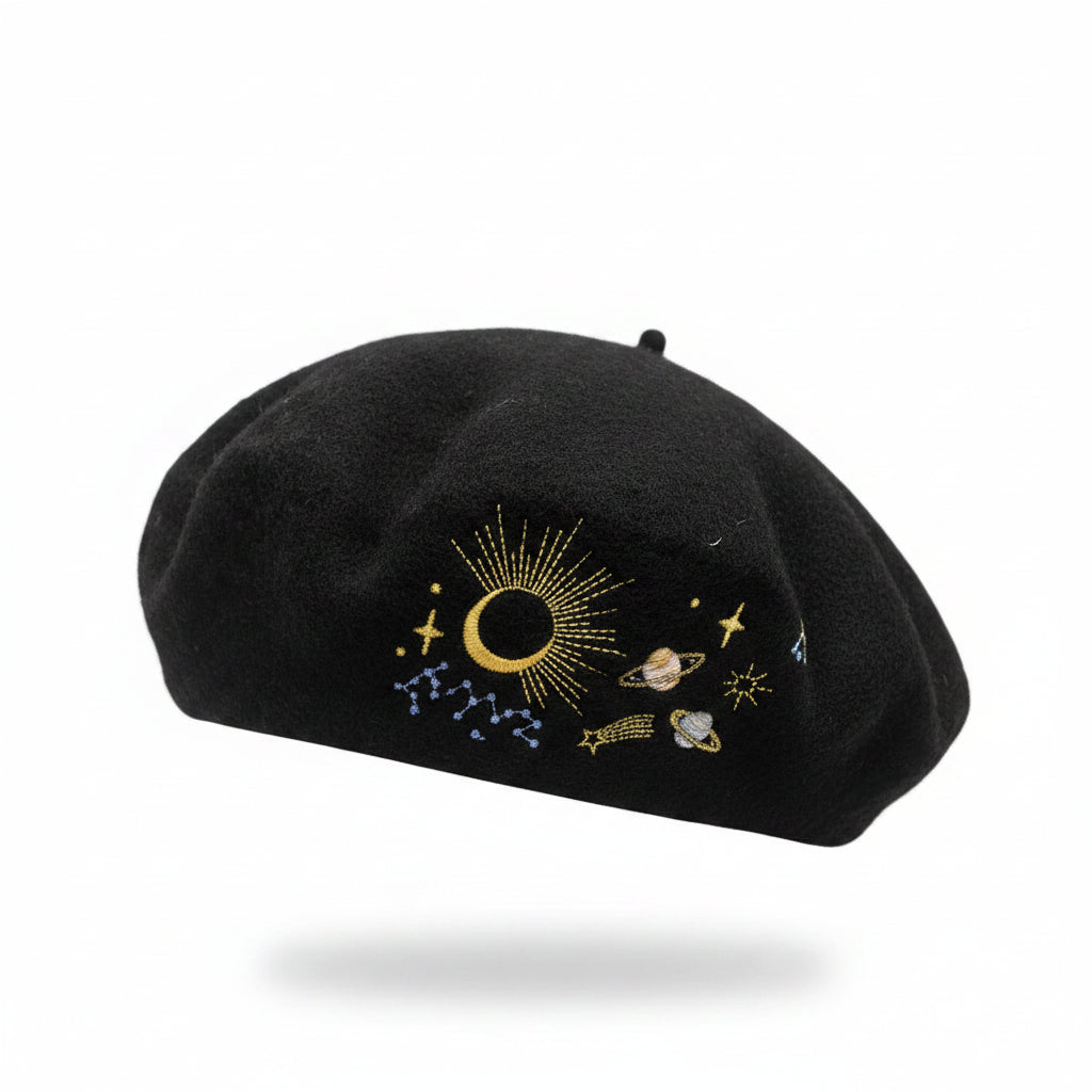Side profile of woman wearing black wool beret with gold embroidered moon and stars.
