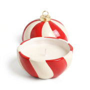 Close-up of Candy Cane Stripe Cinnamon Bauble Candle being lit, showing red and white ceramic design.
