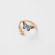 Enamel Blue Butterfly Ring with gold-plated band and hand-painted blue butterfly charm beside clear crystal gems.