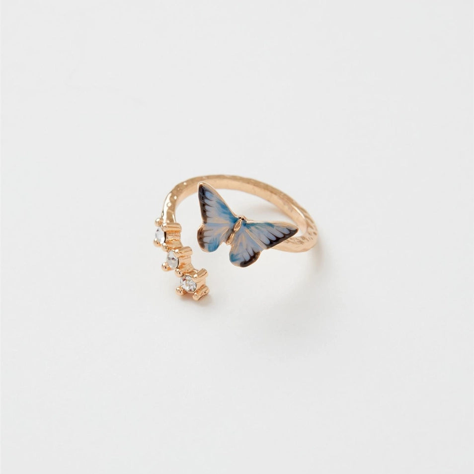 Enamel Blue Butterfly Ring with gold-plated band and hand-painted blue butterfly charm beside clear crystal gems.