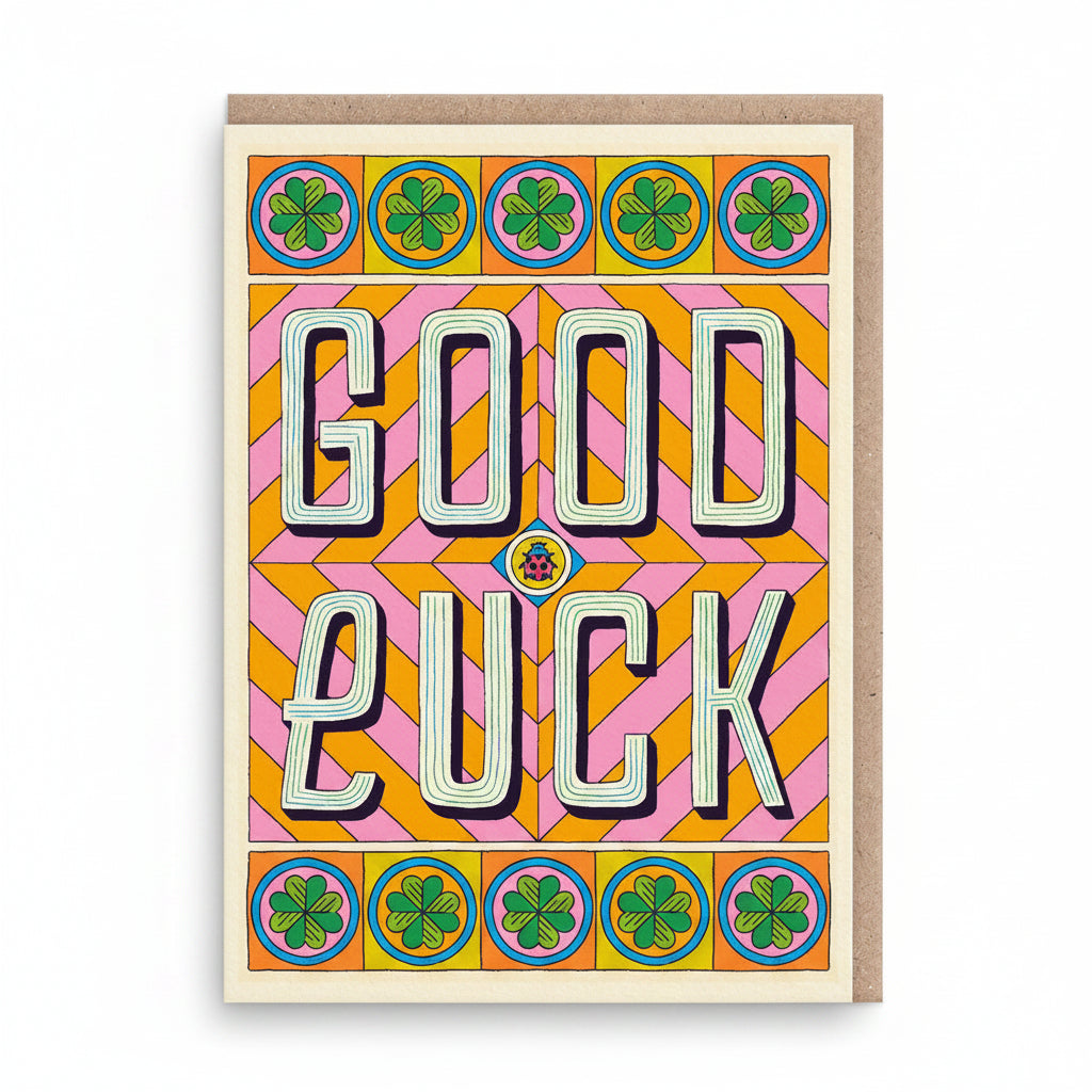 Cream good luck card with bold retro lettering and green four-leaf clovers