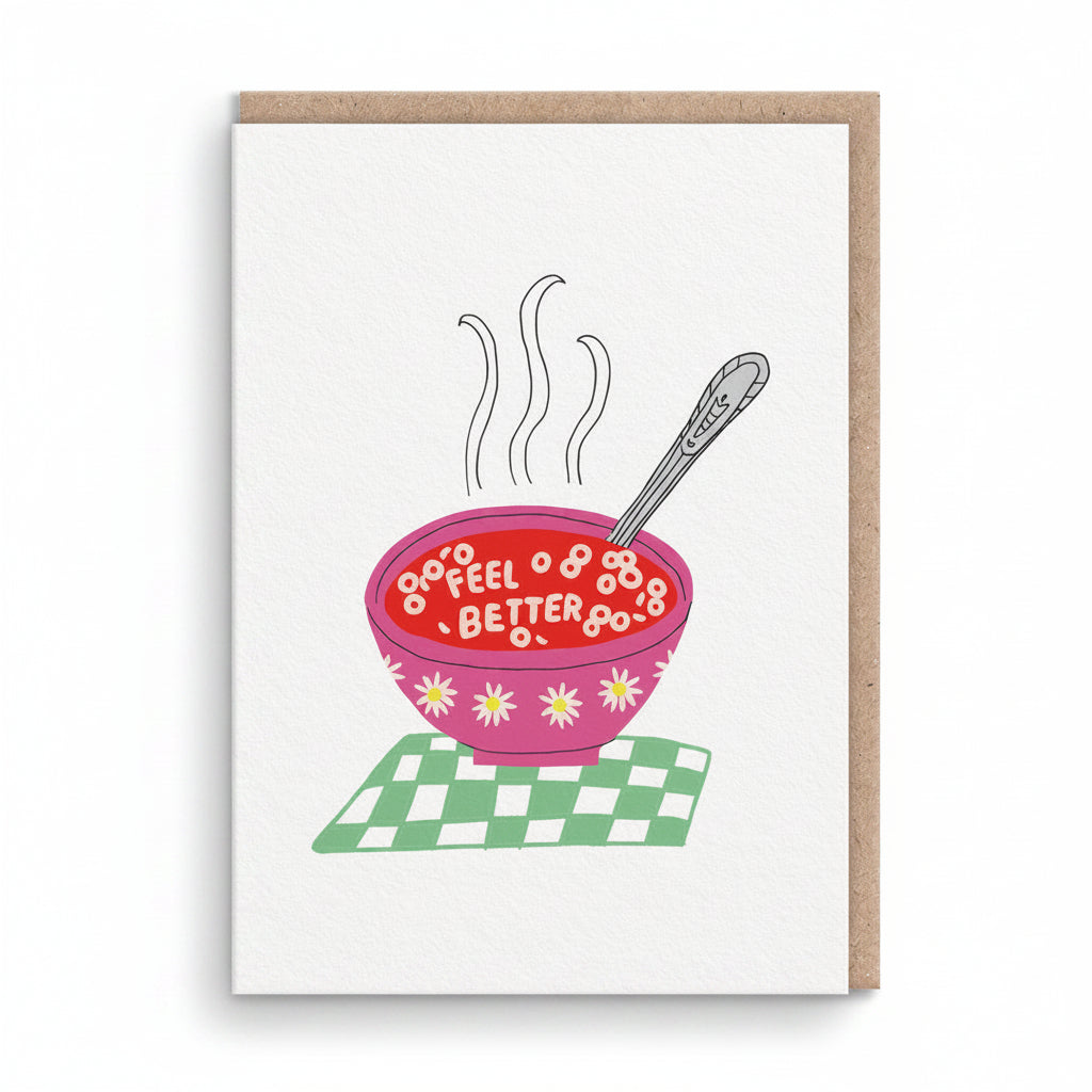 White get well card with a pink bowl of soup spelling feel better