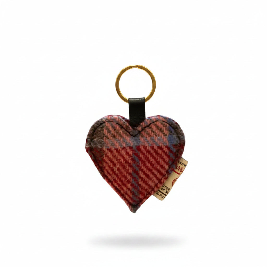 Heart-shaped keychain with plaid pattern held by a hand against a blurred background