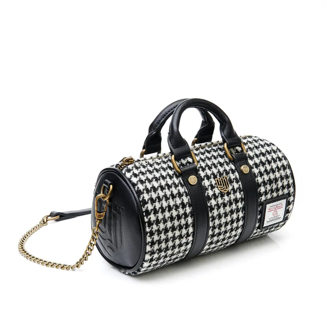 Angled view of black and white dogtooth Harris Tweed mini duffel bag