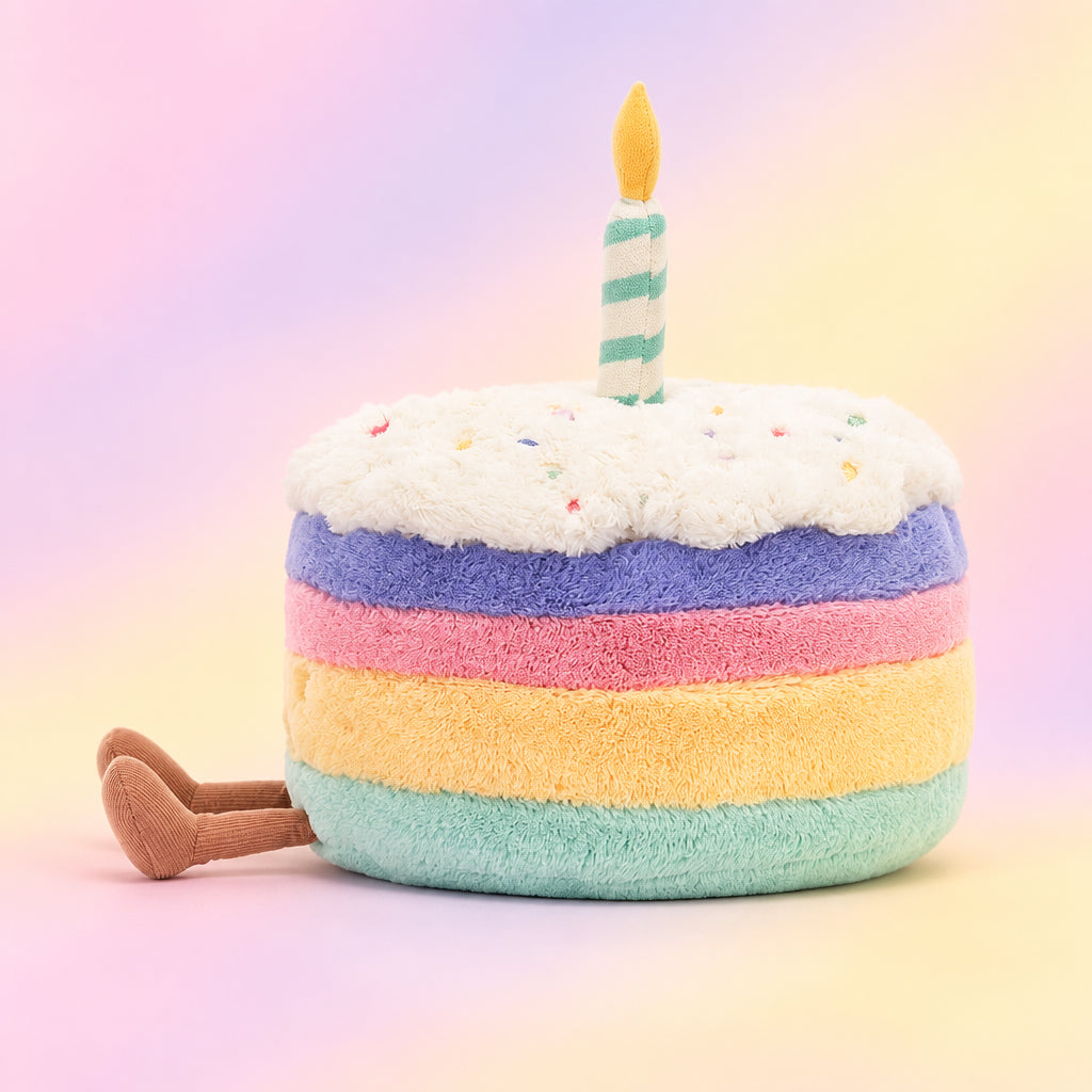 Dive into the details of the Amuseable Rainbow Birthday Cake! Each layer boasts a different vibrant color, topped with fluffy icing and a fun suedette candle. A cuddly gift for all ages!