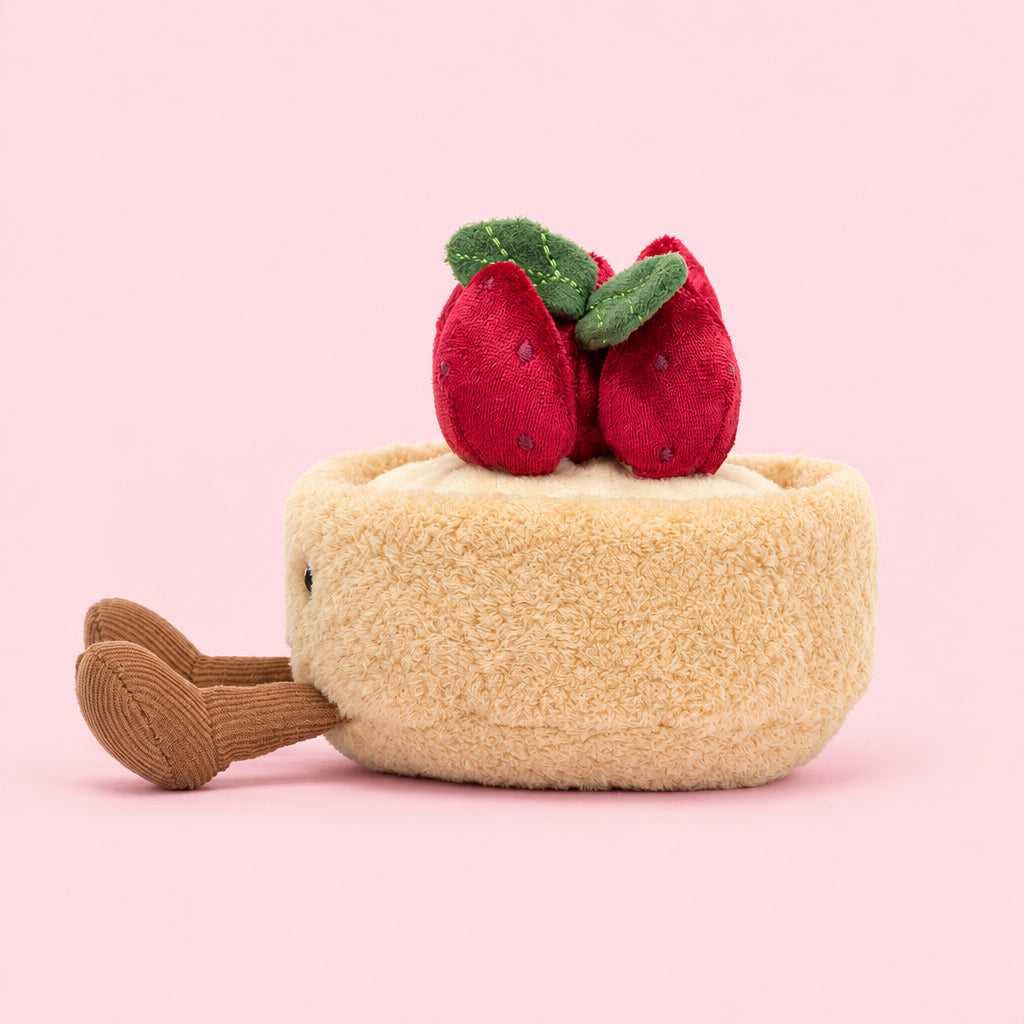 Side view of Jellycat Amuseables Fleurette Tarte Aux Fraises showing plush red strawberries with green leaves.
