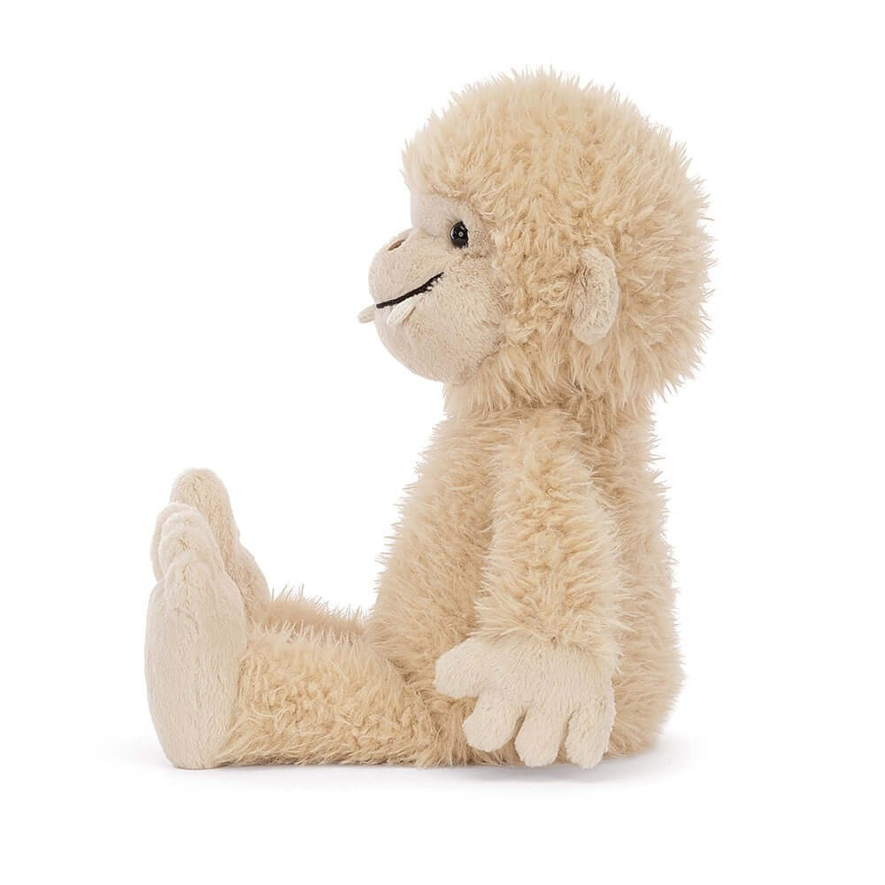A side view of the playful Jellycat Bucky Bigfoot, highlighting his scruffy fur, big feet, and perfect size for cuddles.