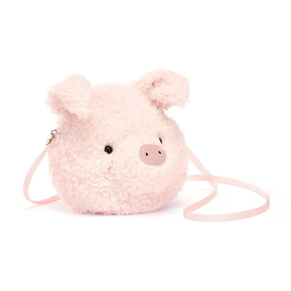Jellycat Little Pig Bag, a small, plushbag shaped like a pigs head with soft pink fur and an embroidered snout. The bag has adjustable straps and a spacious interior compartment.