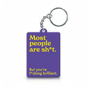 Purple keyring reading most people are sh*t but you're brilliant