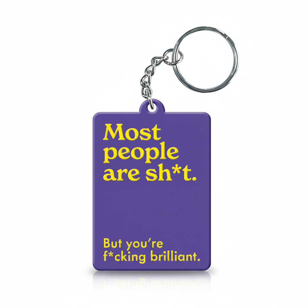 Purple keyring reading most people are sh*t but you're brilliant