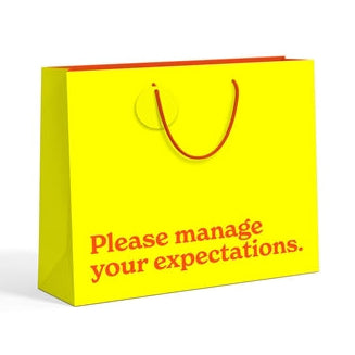 Manage Your Expectations large yellow gift bag - angled view on white background
