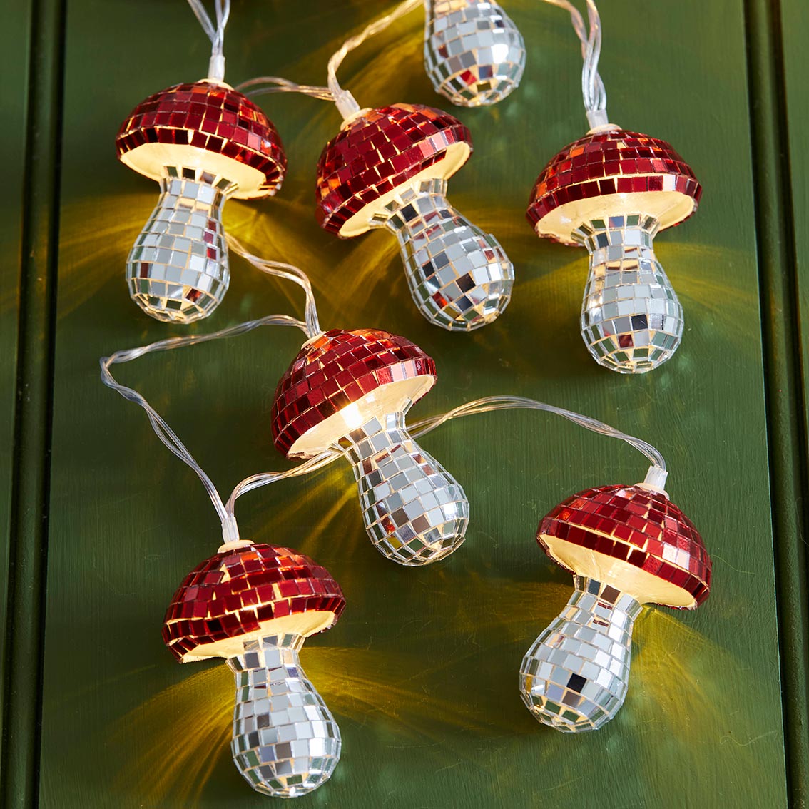 Illuminated Mushroom Disco String Lights glowing against a dark green background.