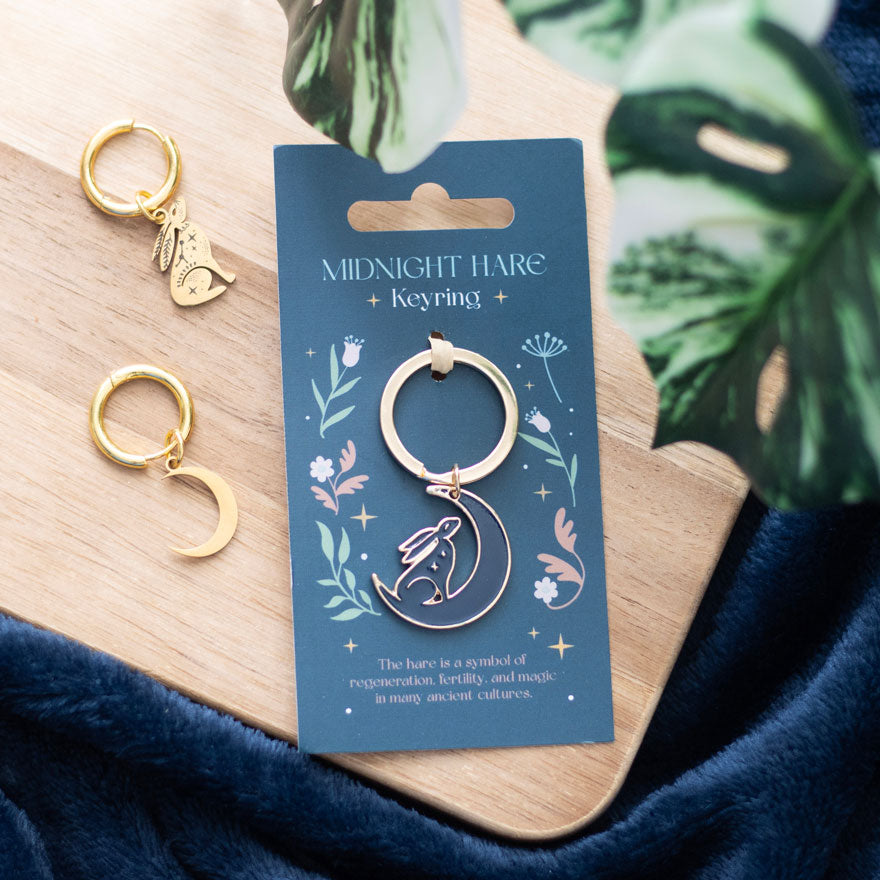 Front view of gold and navy moon gazing hare keyring on floral card.