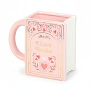 Pink book shaped ceramic mug with gold lettering “I Love Books” on white background.