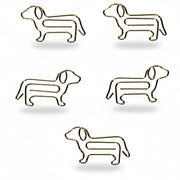 Close-up of five individual gold dog-shaped paper clips laid out on a white background, showing their sleek metal design and charming silhouette detail.