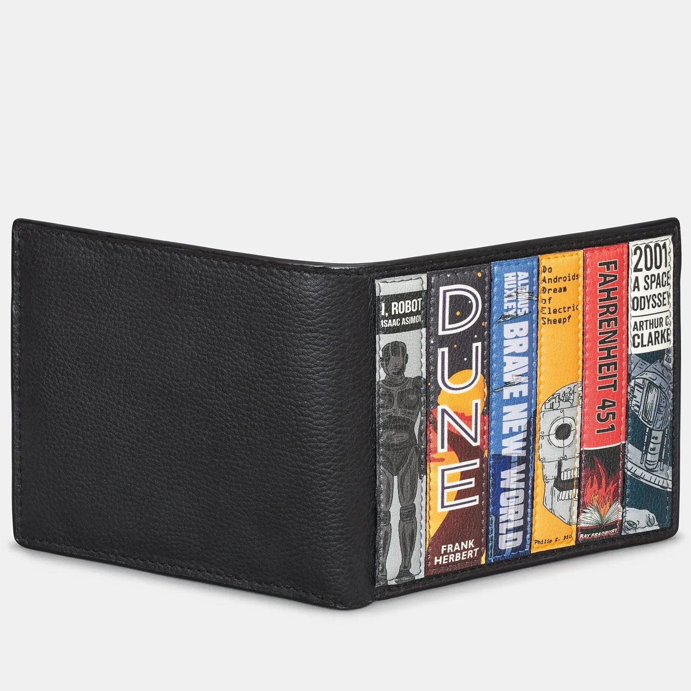 Close-up of science fiction book applique on black leather wallet featuring Dune and Brave New World.