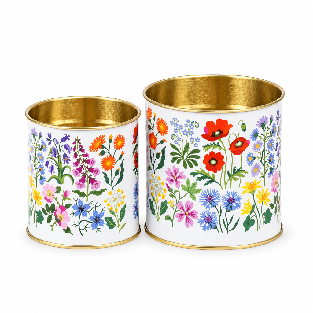 Close-up of two floral storage tins with gold interior and vintage botanical prints.