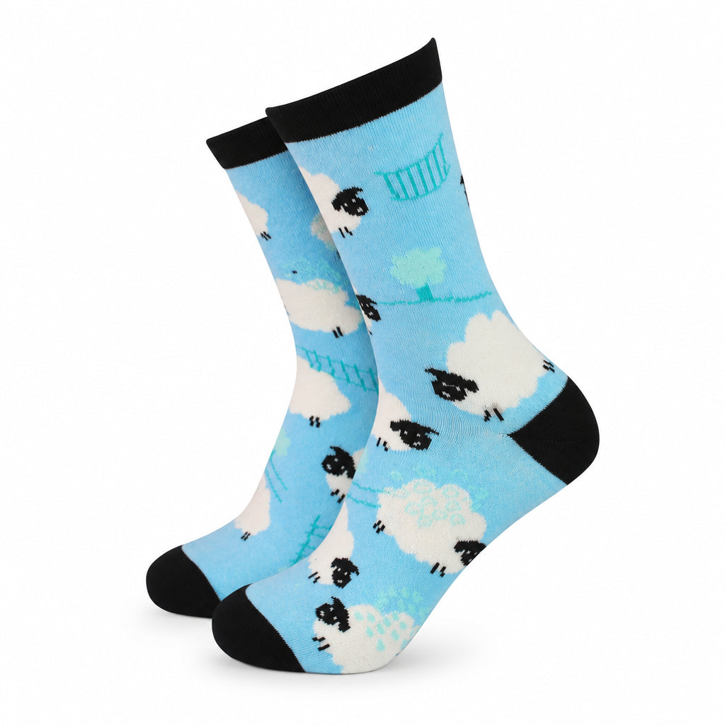 Blue bamboo socks featuring a playful black and white sheep pattern, with black toe, heel, and cuff detailing, shown from a side angle on a white background.