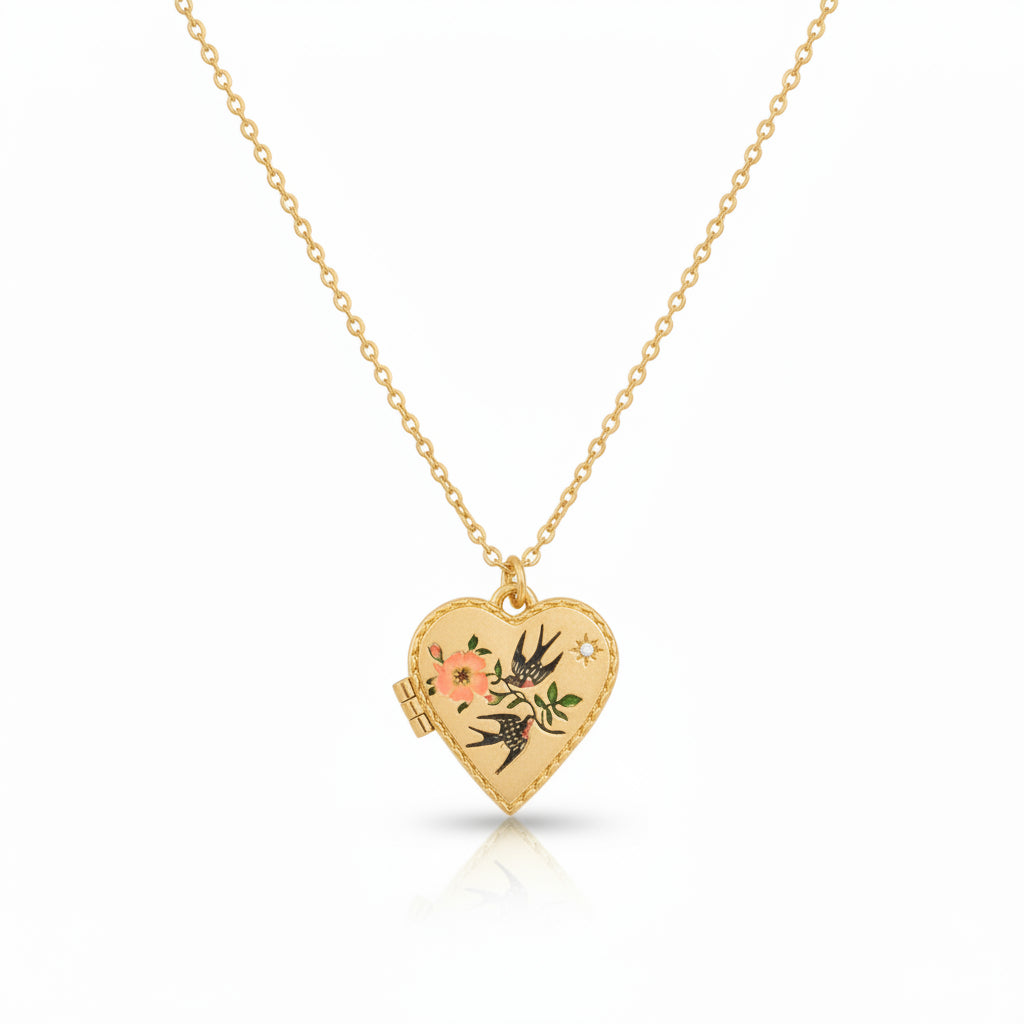 Gold-plated heart locket necklace featuring a hand-painted enamel design of two swallows and pink flowers on a fine chain.