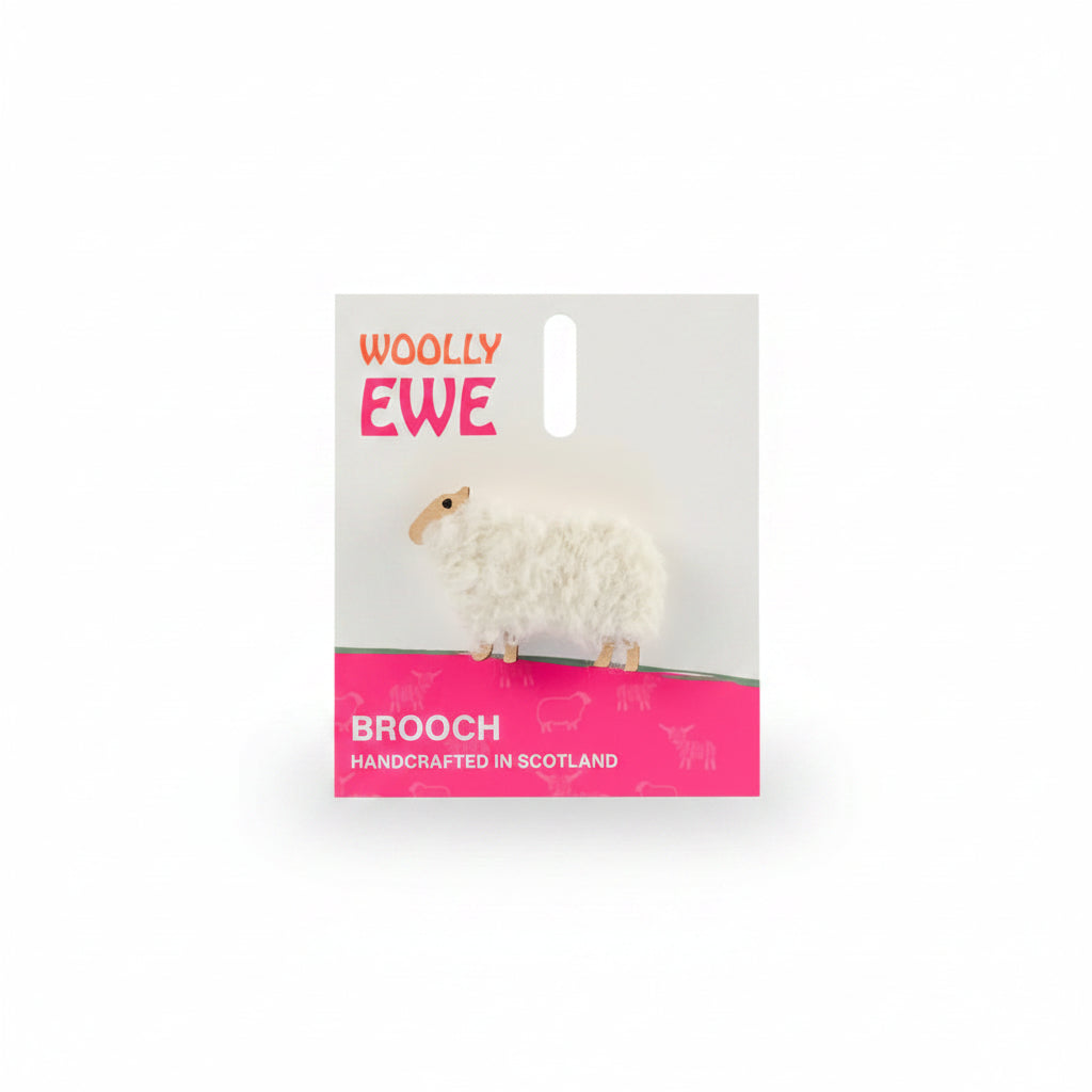 Handcrafted Woolly Ewe brooch on branded card with pink label, featuring fluffy white wool and wooden sheep design, made in Scotland.