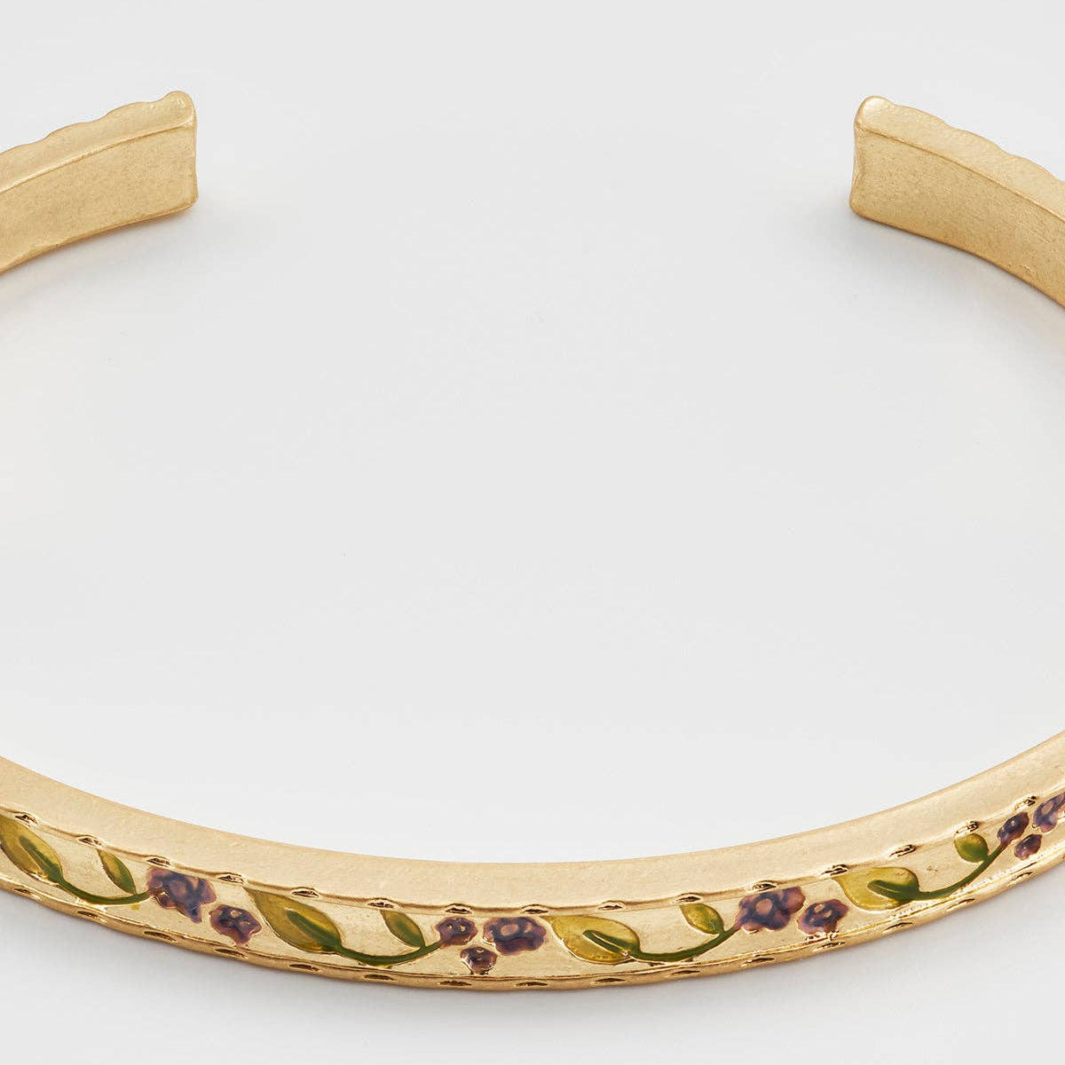 Etched bramble vine detail along the worn gold cuff