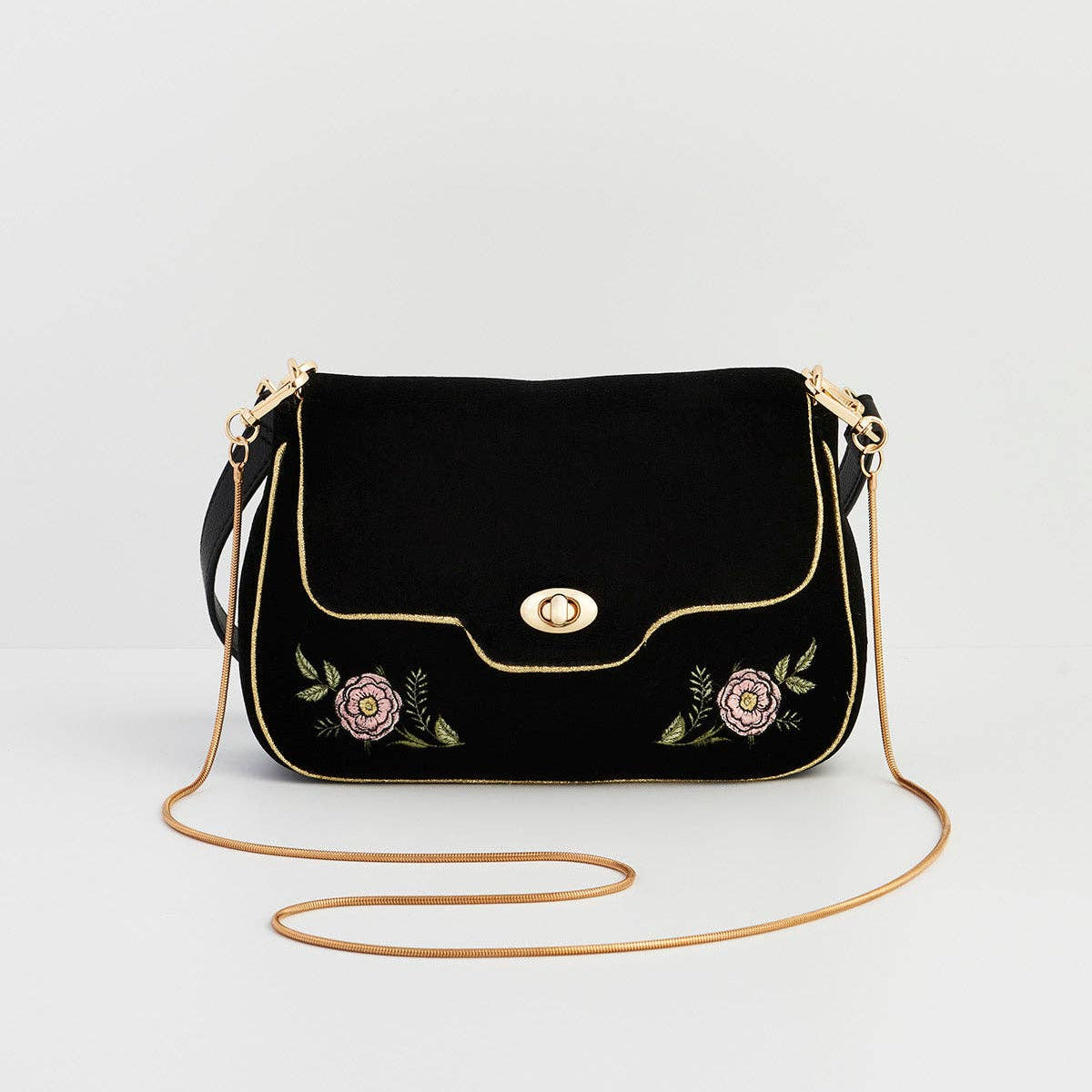 Black velvet rose embroidered clutch with gold chain on grey background
