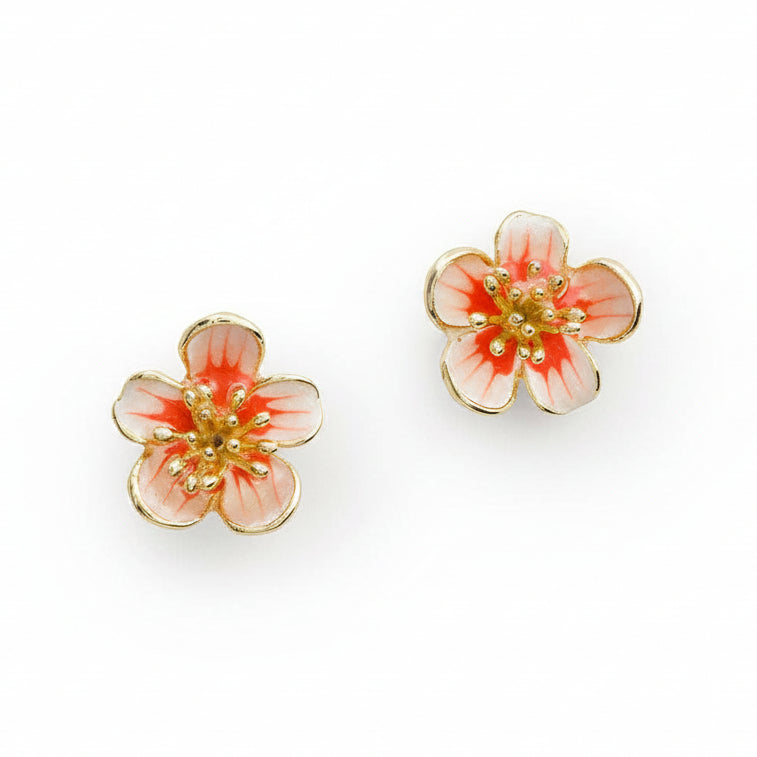 Apple blossom stud earrings pair with pink enamel petals and coral centres on white background