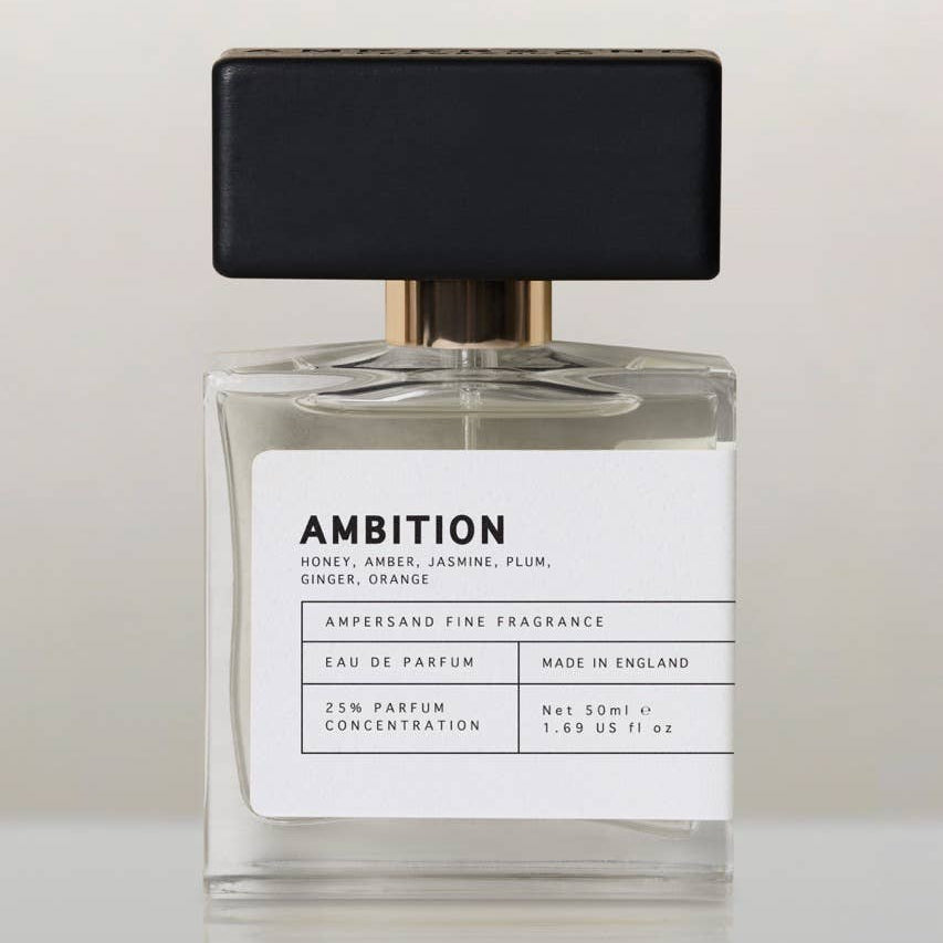 Ambition eau de parfum bottle with black cap, front view on cream background