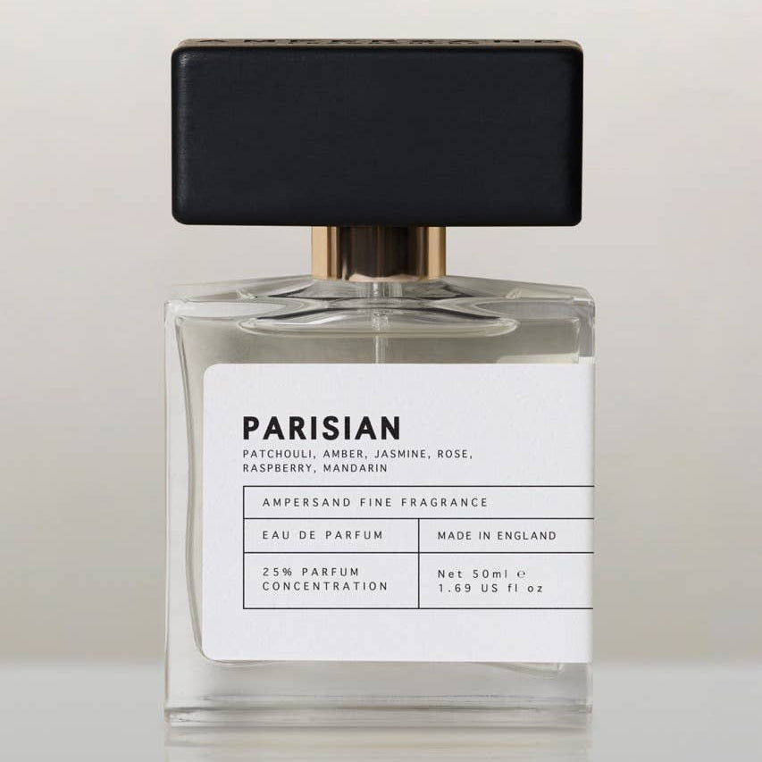 Parisian eau de parfum bottle with black cap, front view on cream background