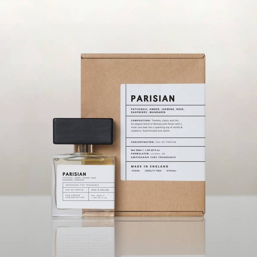 Parisian perfume bottle beside its recycled kraft gift box, cream background