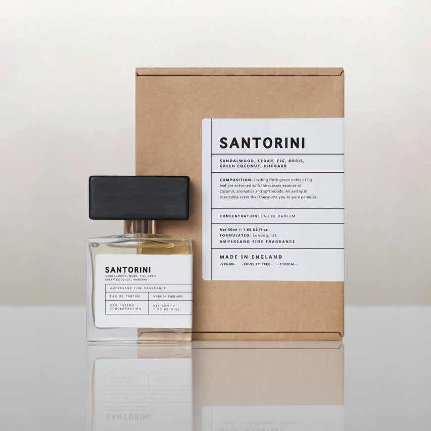 Santorini perfume bottle beside its recycled kraft gift box, cream background