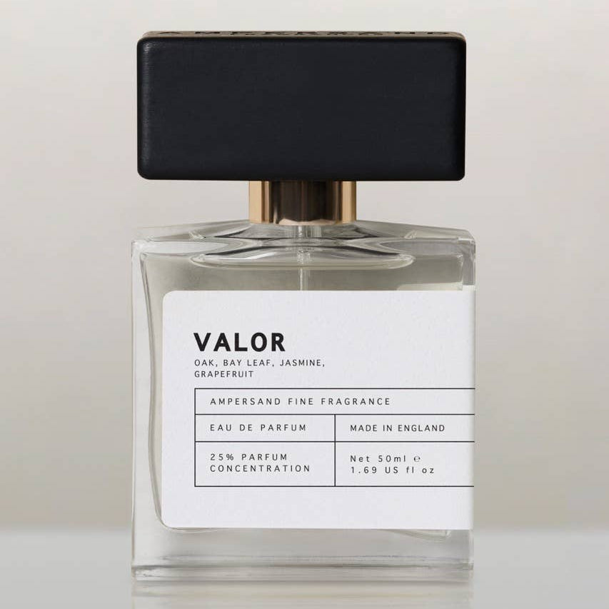 Valor eau de parfum bottle with black cap, front view on cream background