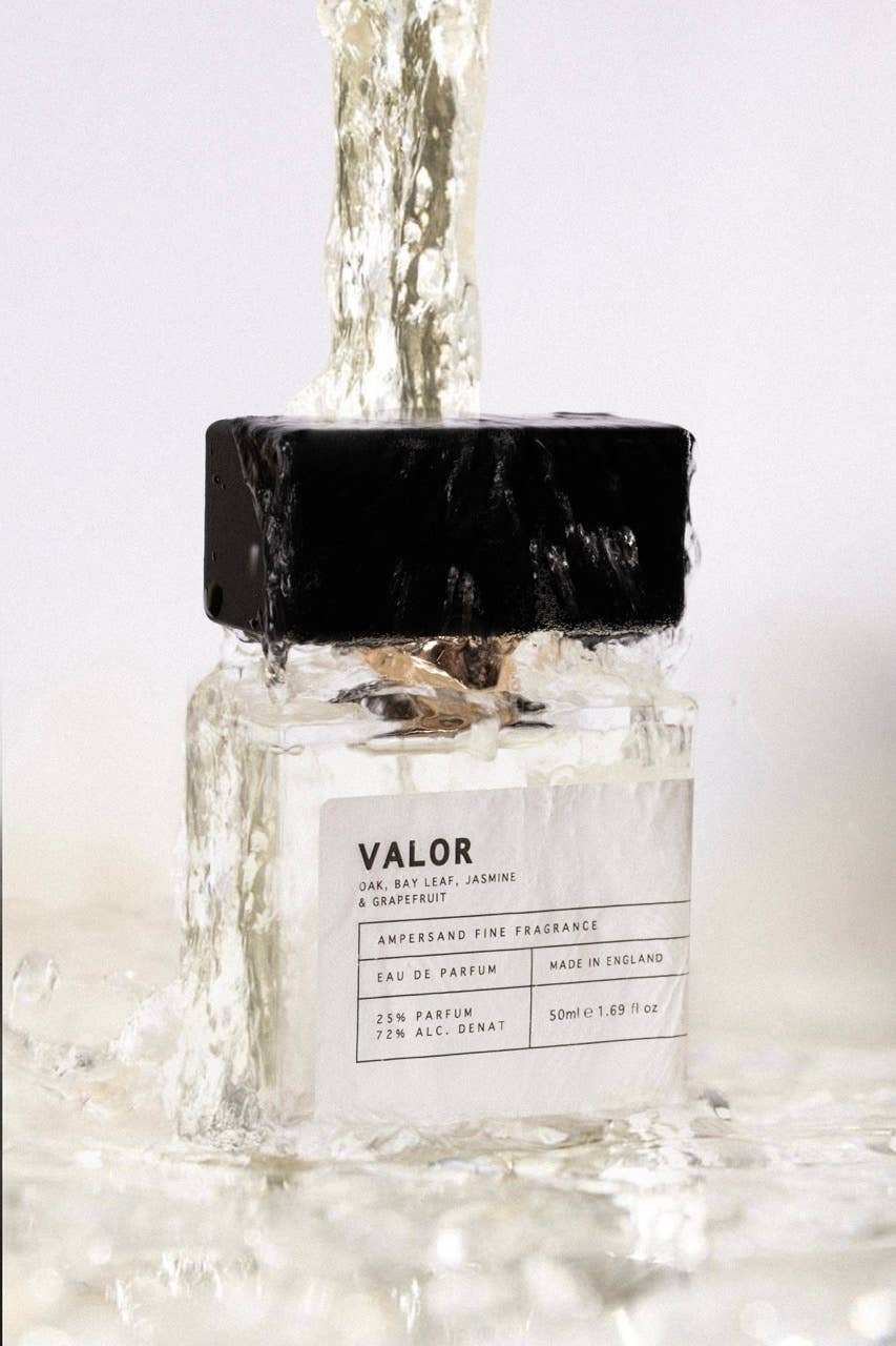 Valor eau de parfum bottle with water splashing over it, white background