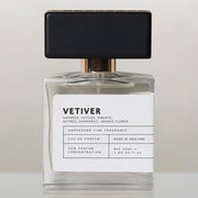 Vetiver eau de parfum bottle with black cap, front view on cream background