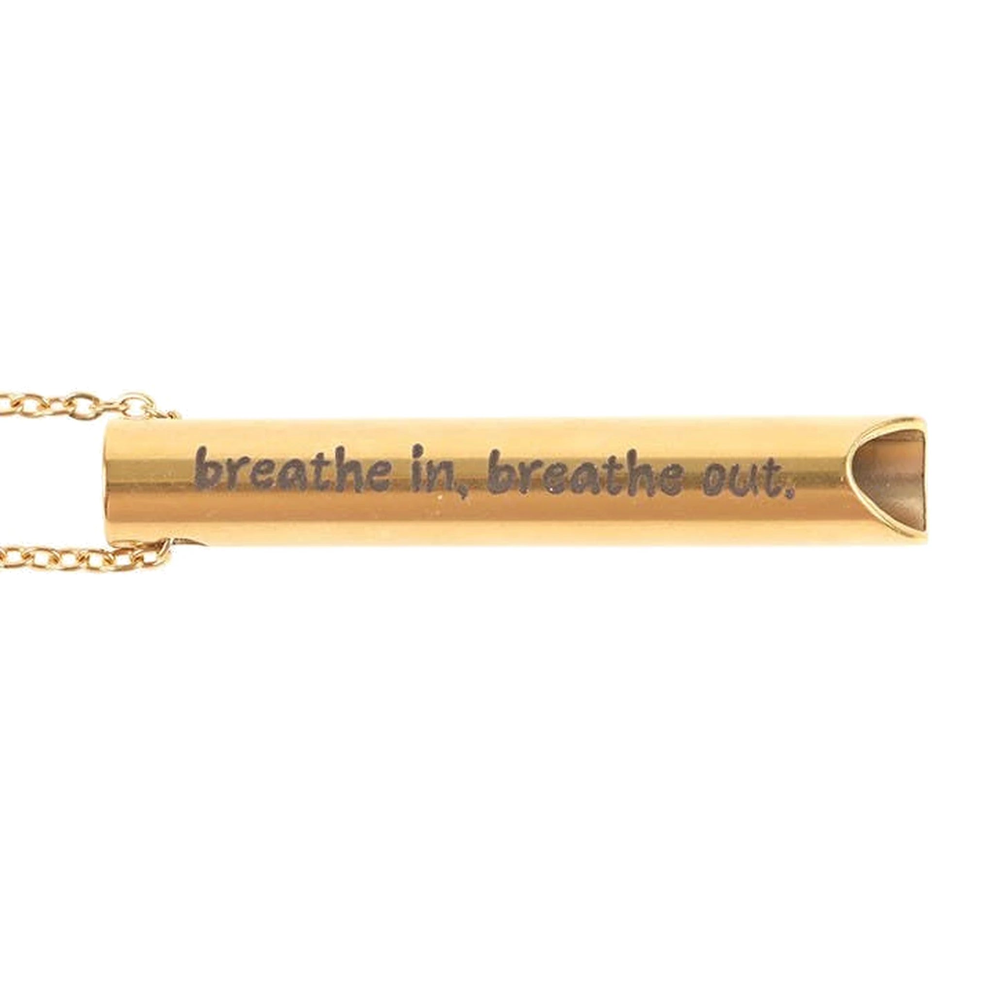 Close-up of gold breathing necklace pendant engraved breathe in, breathe out, on white.