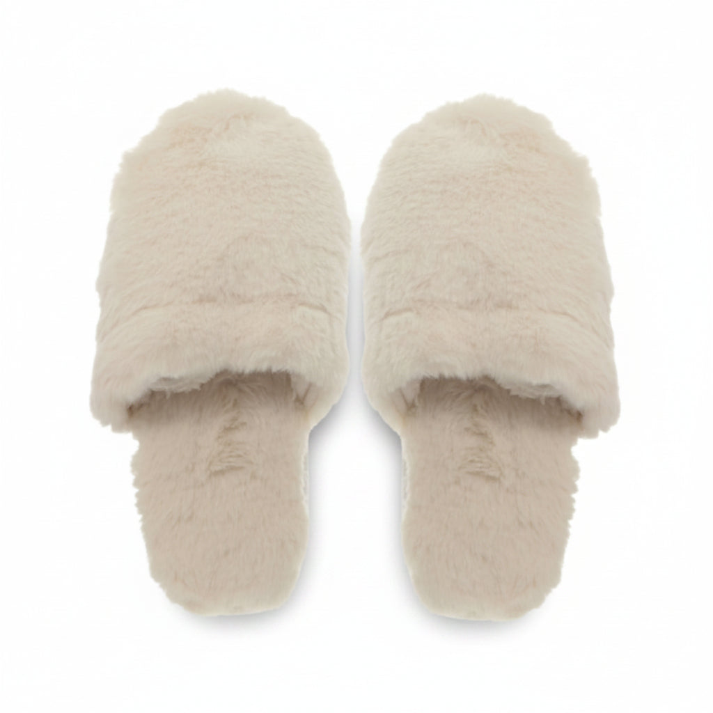 Pair of cream faux fur open toe mule slippers viewed from above on white