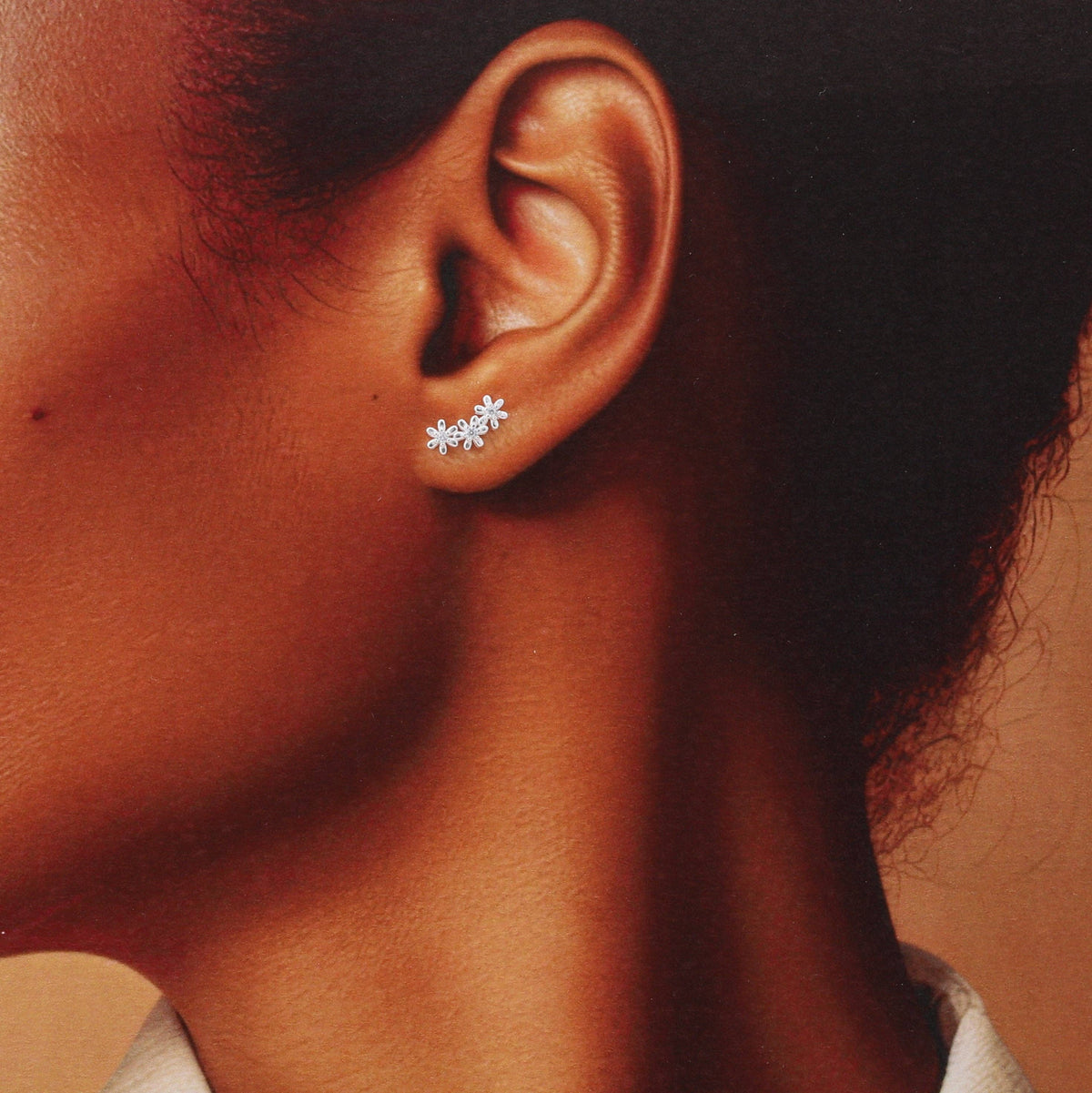 Woman wearing clear crystal flower stud earring in lifestyle close-up