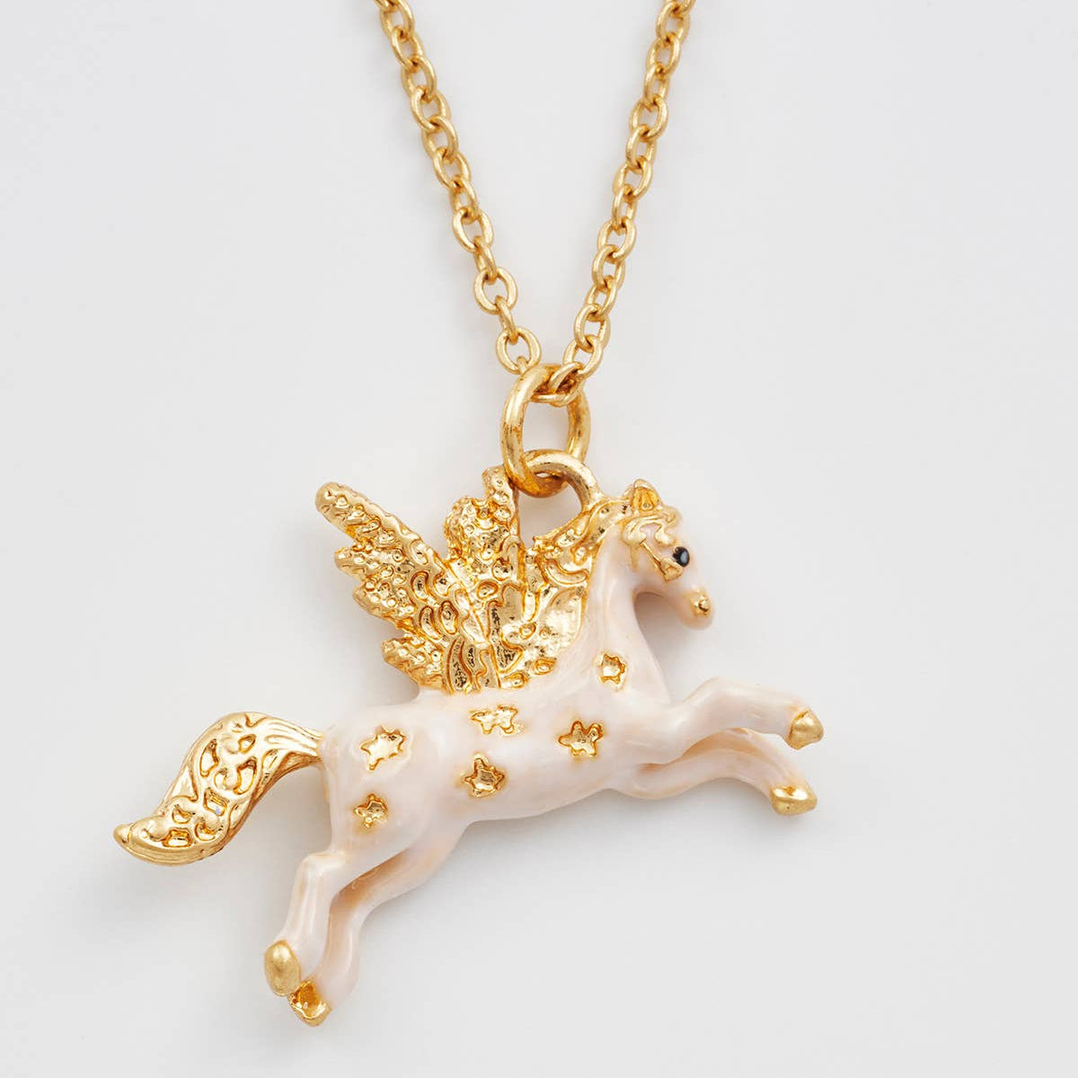 Close up of the enamel Pegasus pendant with gold wings and mane