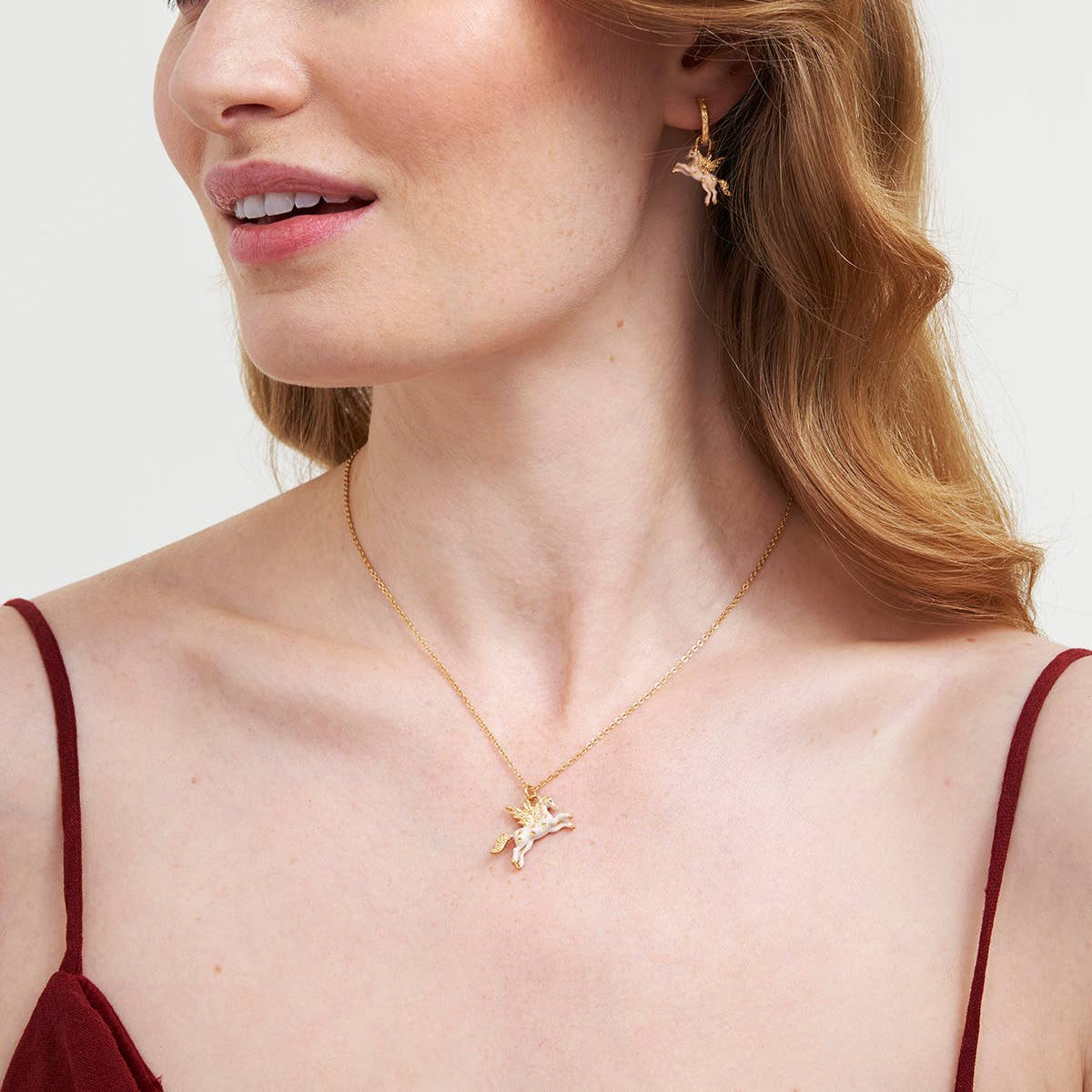 Woman wearing the Pegasus pendant necklace with matching star earrings