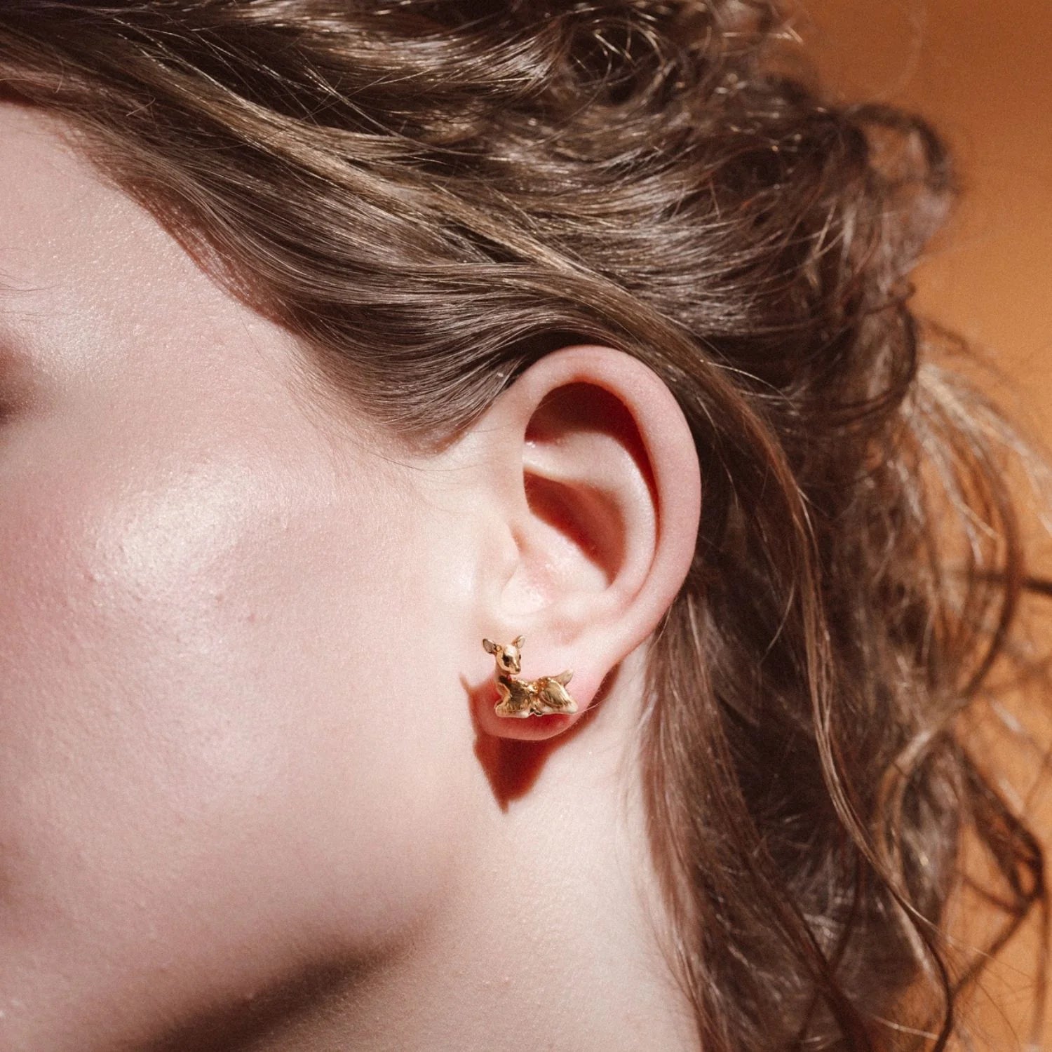 Side profile of model wearing Bill Skinner Fawn Stud Earrings with natural lighting.