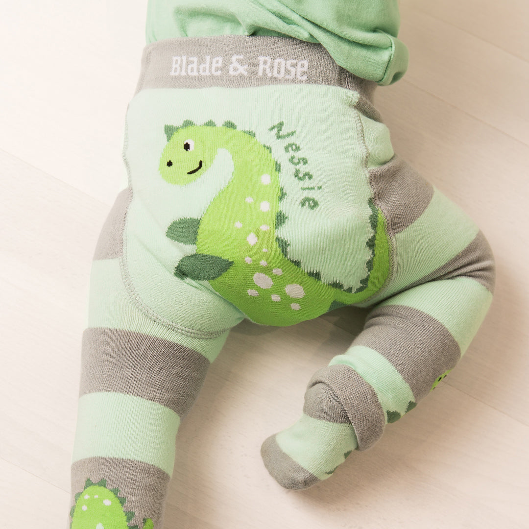 Baby crawling in green Nessie leggings with the monster print on the bottom