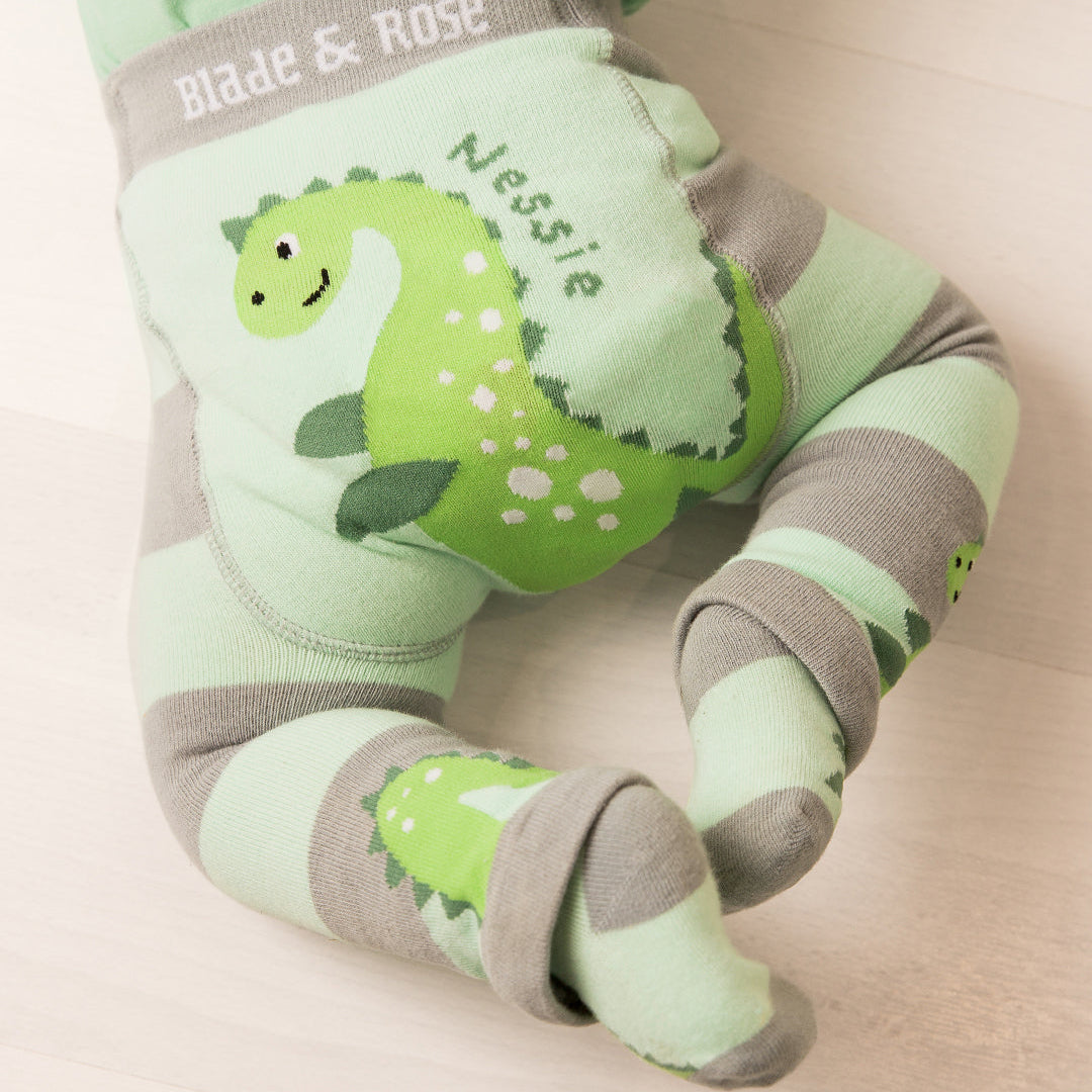 Grey and mint striped Nessie leggings seen from the side on a seated baby
