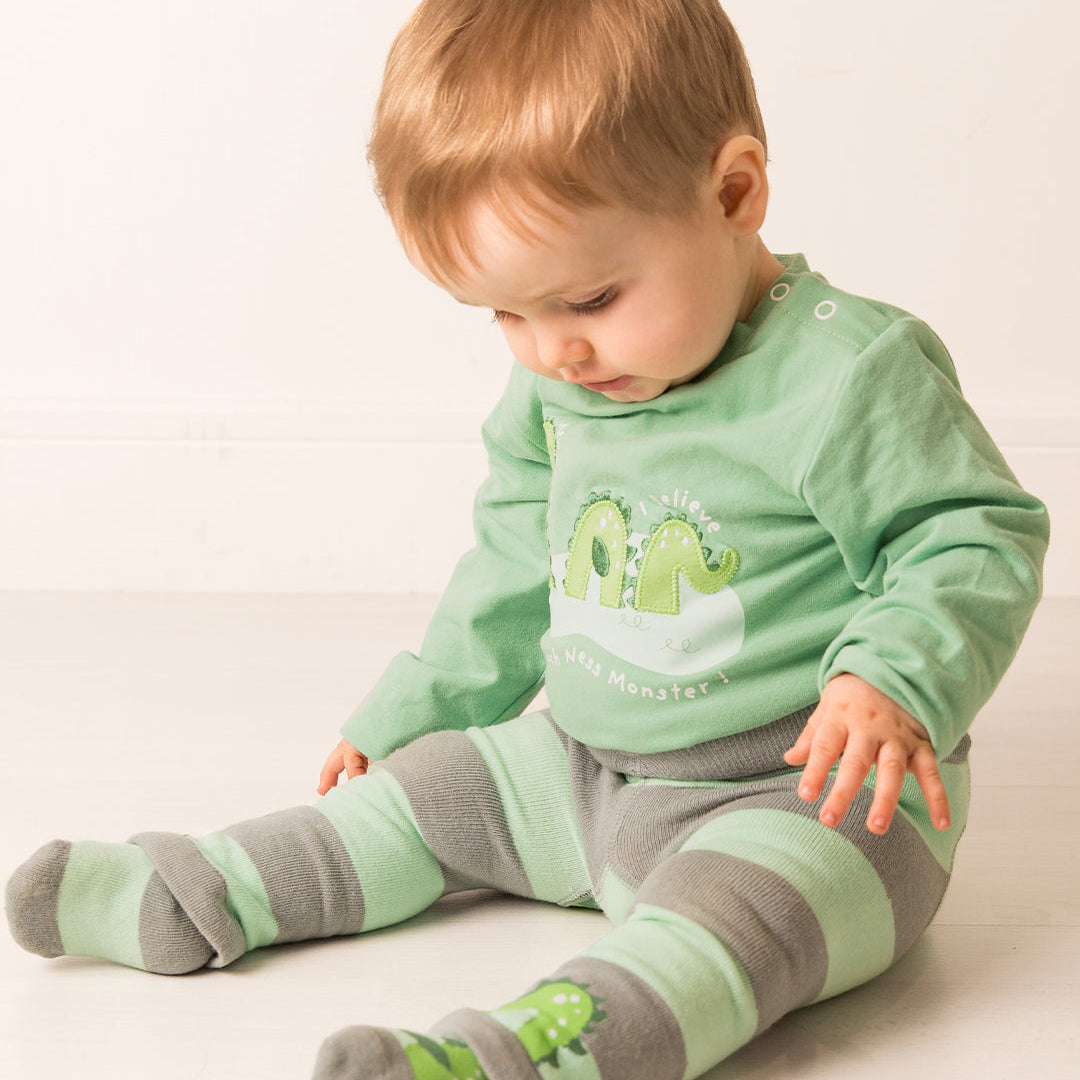 Toddler wearing the green Nessie top with grey and mint striped leggings