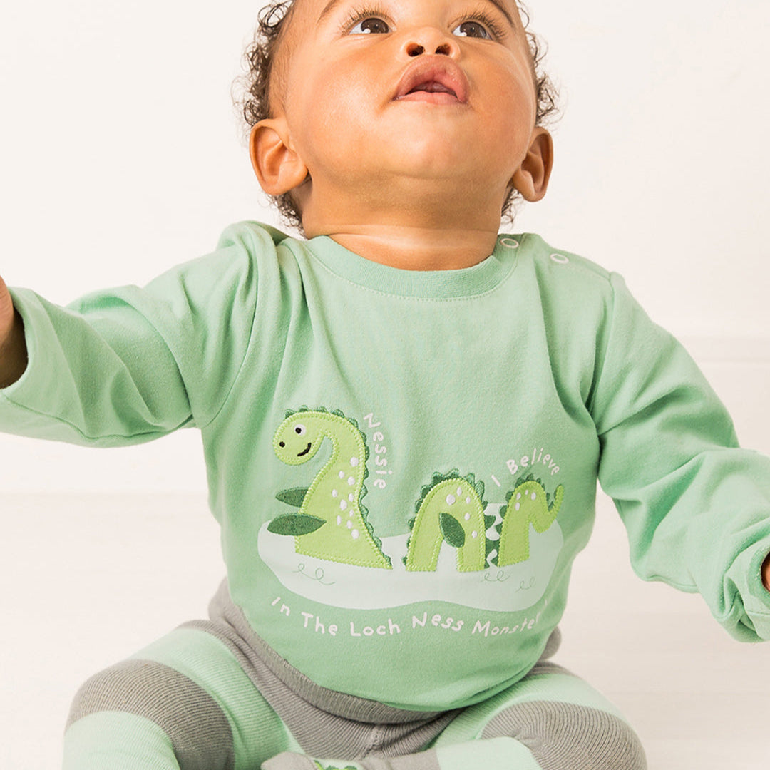 Baby wearing the green Nessie long sleeve top and matching striped leggings