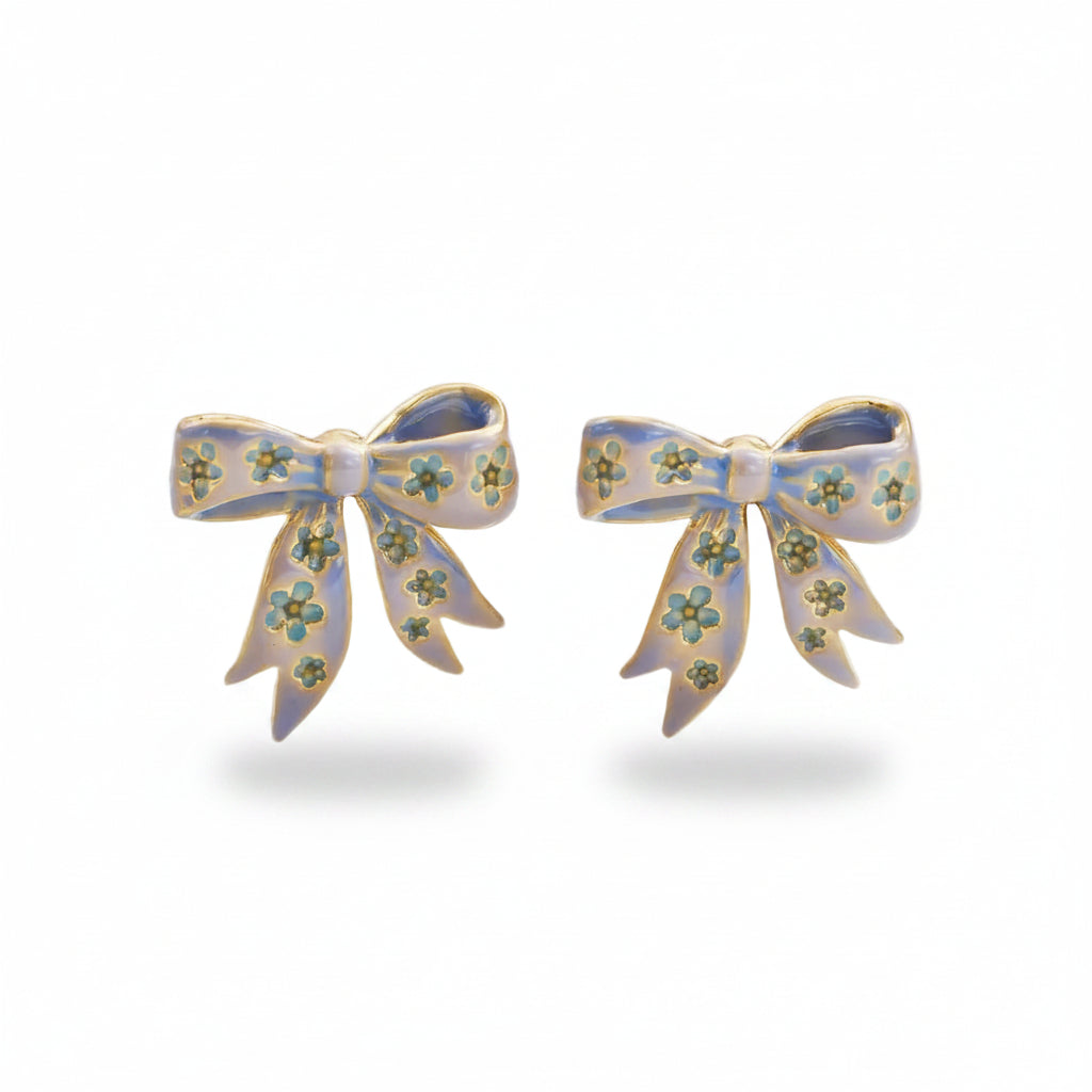 Bow stud earrings in gold with blue enamel detailing on white background