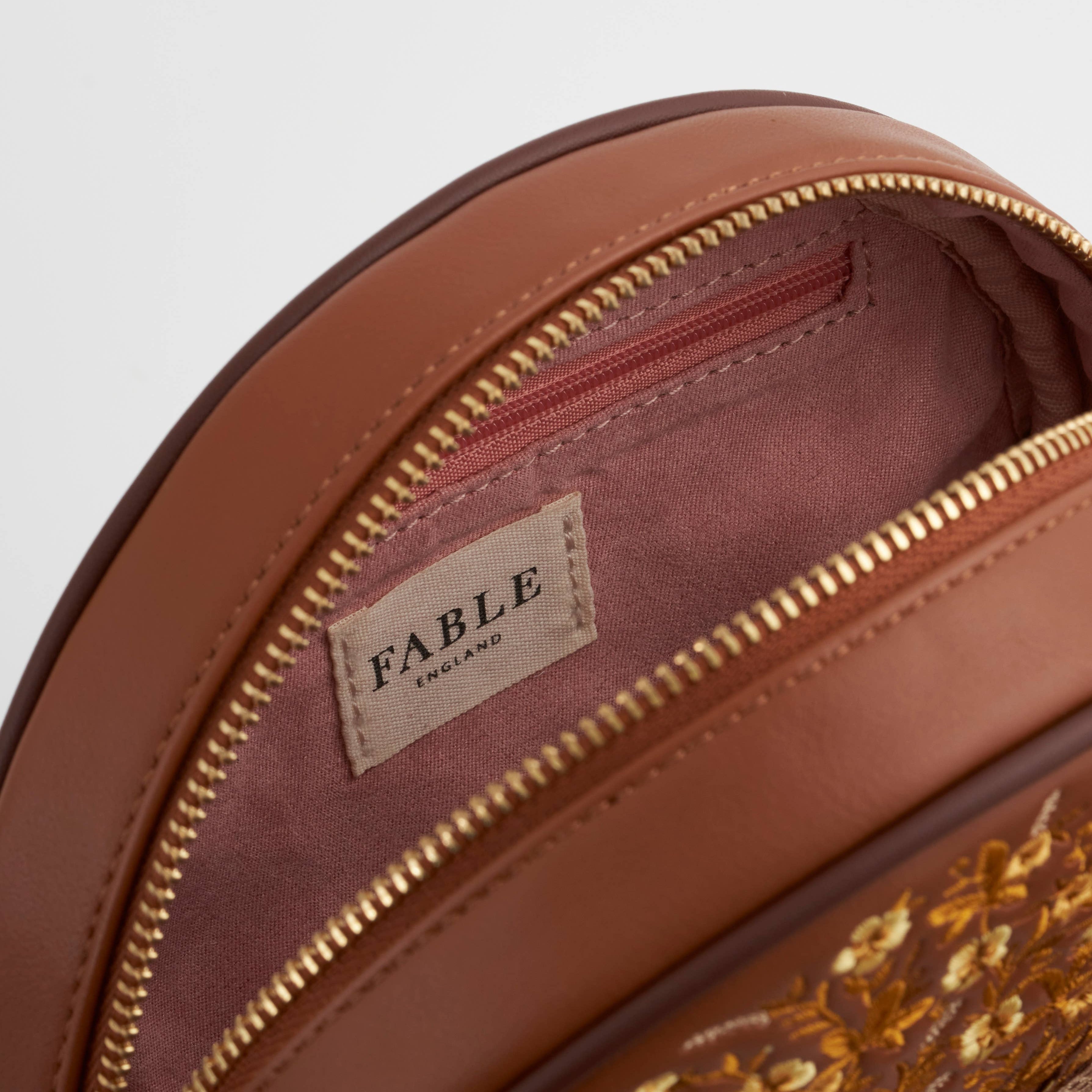 Inside the circle purse showing the lined interior and zipped pocket
