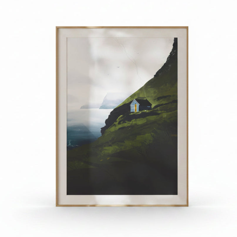 Framed artwork of a house on a hillside with a mountainous background.